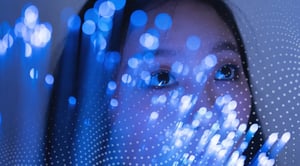 A woman peering behind blue fiber optic lights